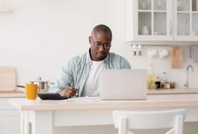 Man on computer in his kitchen